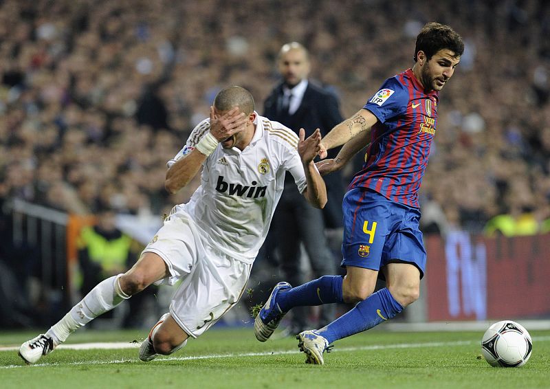 Real Madrid's Pepe falls next to Barcelona's Fabregas during their Spanish King's Cup soccer match in Madrid