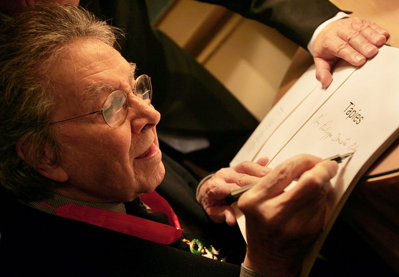 Antoni Tápies firma un libro tras recibir la medalla nacional de la Legión de honor de Francia