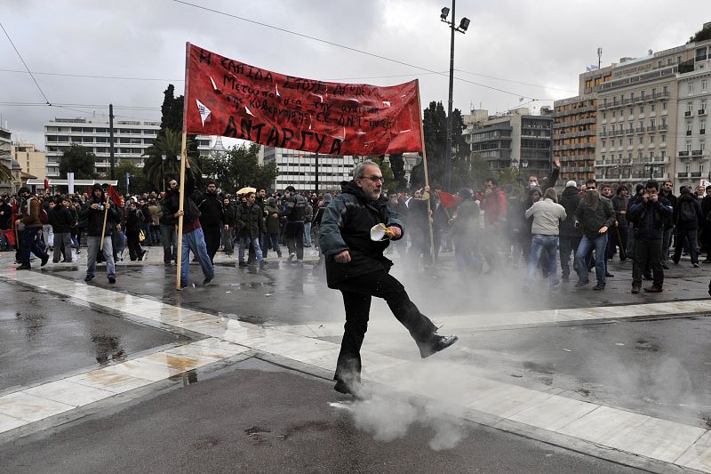 Uno de los manifestantes devuelve un bote de gas lacrimógeno lanzado por la policía a los agentes