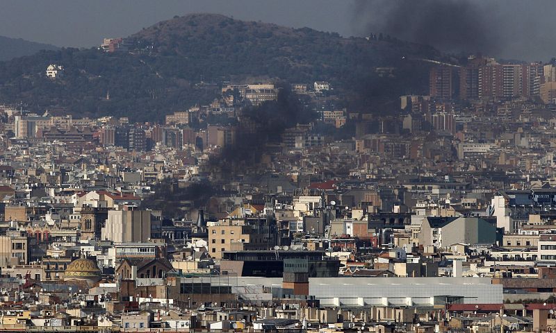 Smoke billows from burning furniture set fire upon by students protesting against spending cuts in public education in Barcelona