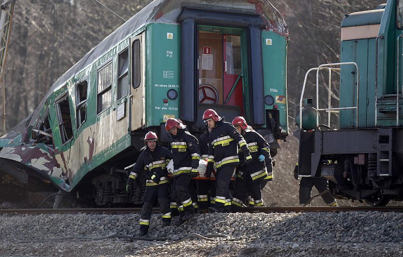Polish emergency services workers carry the body of a victim of a train crash near the town of Szczekociny