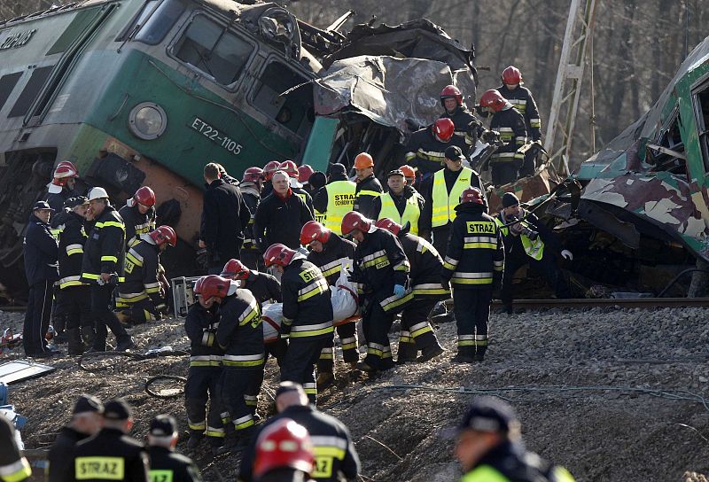 Polish emergency services workers remove the body of the 16th victim of a train crash near the town of Szczekociny