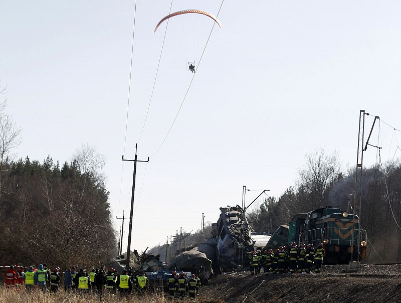 A para glider flies over the site of a train crash near the town of Szczekociny