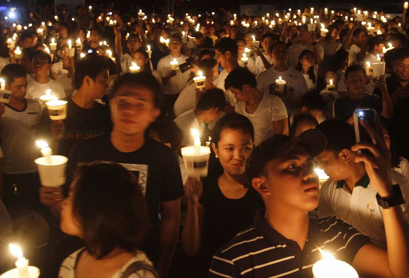 Participants hold candles as they join the celebration of Earth Hour in Manila's Makati financial district