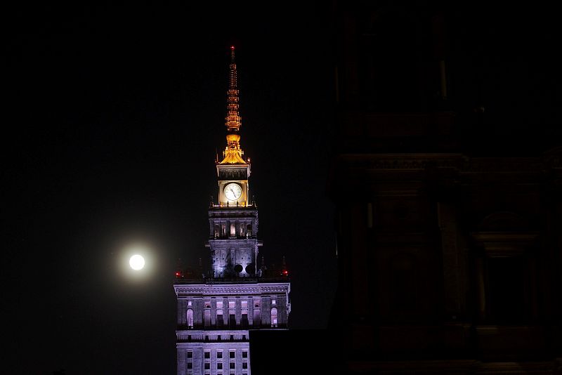 La luna llena brilla junto al Palacio de la Cultura y la Ciencia en Varsovia, Polonia.