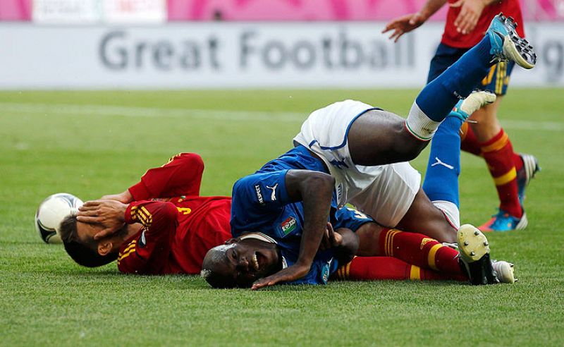 Balotelli y Piqué, en el suelo, en una acción en el área de España.