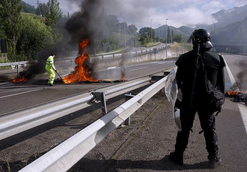 Efectivos de seguridad y limpieza retiran una barricada de los mineros en Campomanes