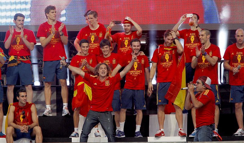 El cantante David Bisbal (c, primera fila) interpreta una canción junto a los jugadores de la selección española