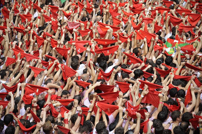 Los pamploneses elevan sus pañuelos rojos al cielo