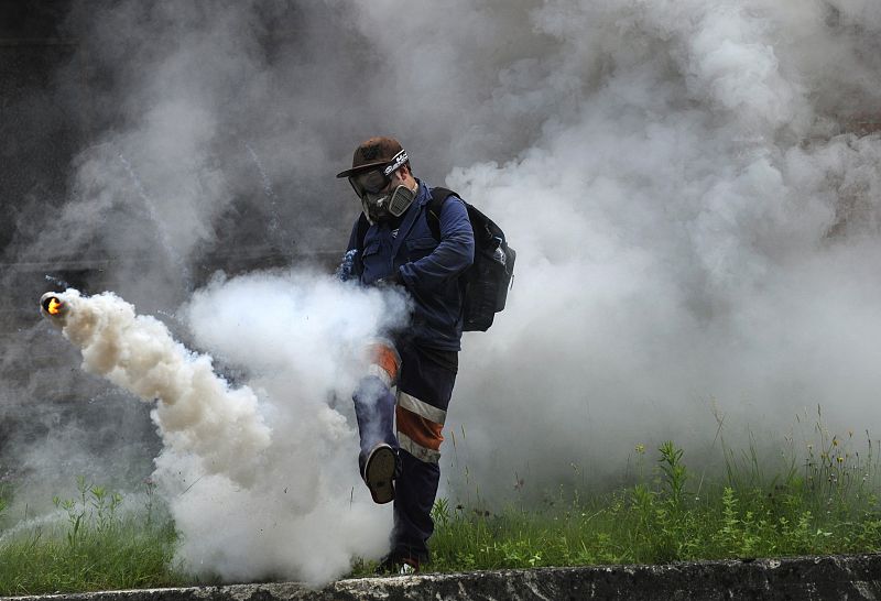 Un minero patea una lata de gas arrojado por la Policía en los disturbios producidos en la mina de El Sotón.