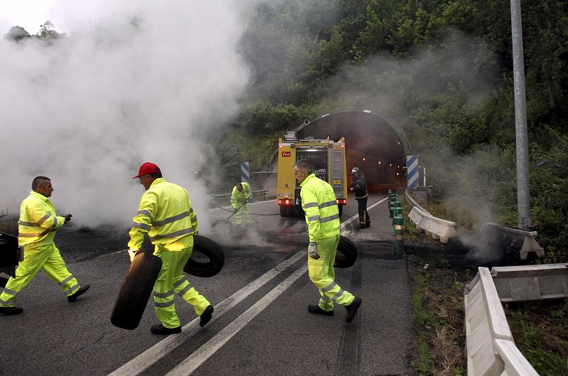 Operarios retiran una barricada con la que los mineros cortaron la carretera A66 en los tuneles del Padrun, cerca de Oviedo