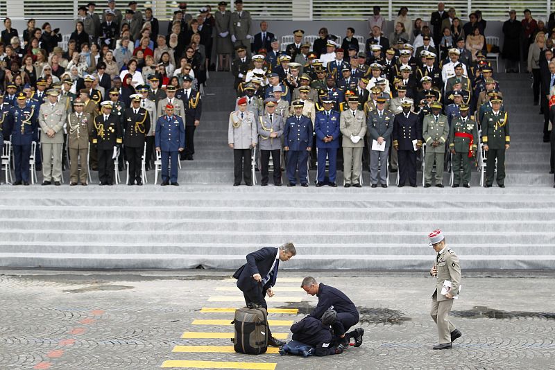 An injured parachutist is assisted by medical staff in front of the reviewing stand at the Place de la Concorde during the traditional Bastille Day military parade in Paris