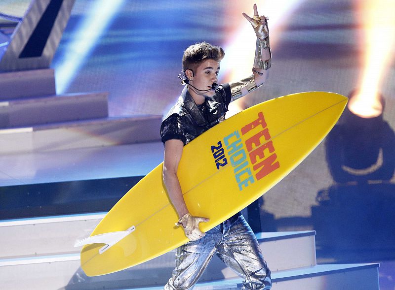 Justin Bieber recoge una de las cuatro tablas surferas que recibió en los Teen Choice Awards 2012.