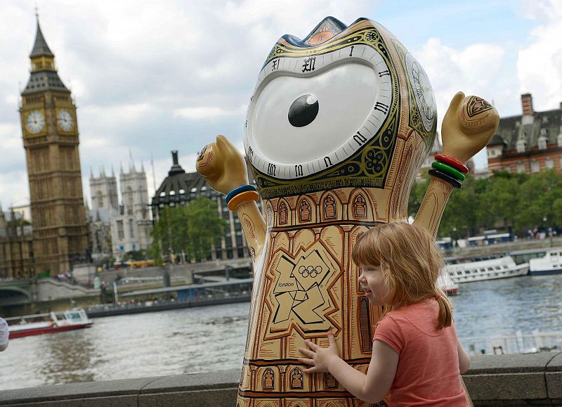 Una niña posa con la mascota olímpica junto al Parlamento británico, en Londres, Reino Unido.
