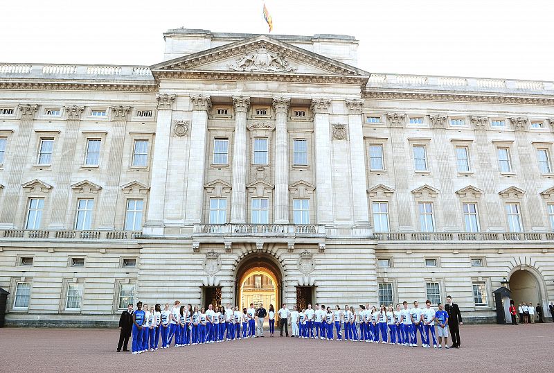 El duque y la duquesa de Cambridge y el príncipe Enrique esperan el relevo de la antorcha olímpica de Londres 2012 entre Wai-Ming y John Hulse junto con 40 niños del Programa Equipo GB Ambición.