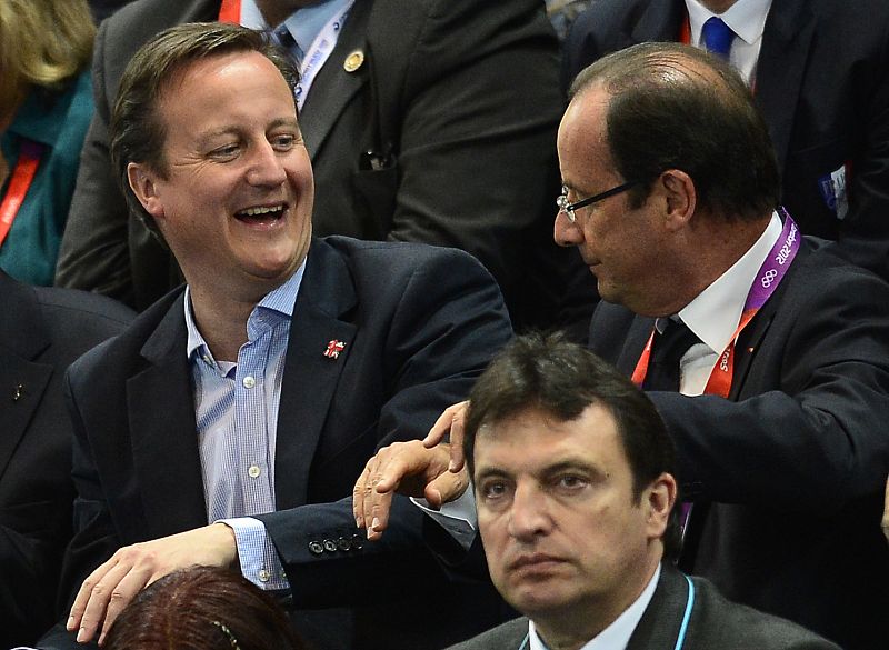El primer ministro británico, David Cameron, y el presidente francés, François Hollande, charlan mientras ven el partido de balonmano femenino entre España y Francia.