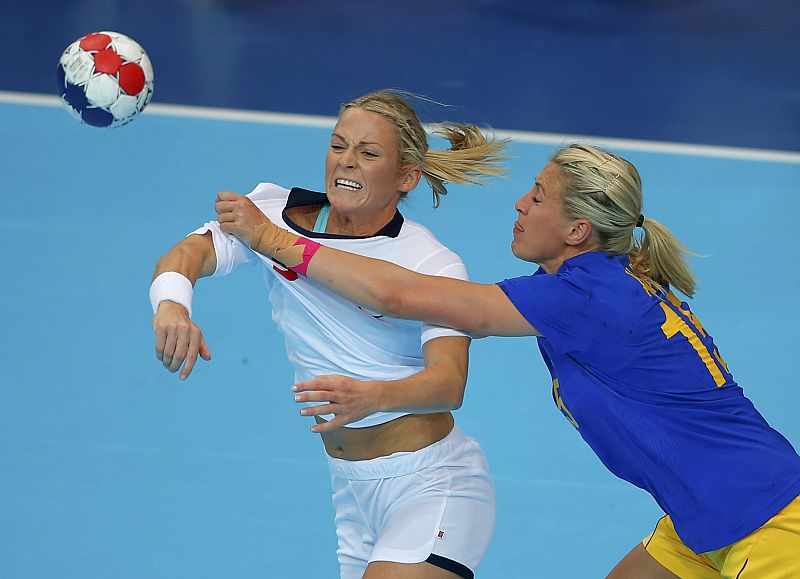 La jugadora noruega de balonmano Ida Alstad lucha por la pelota con la sueca Johanna Ahlm en el partido que ha enfrentado a sus selecciones en la fase de grupos.uring the London 2012 Olympic Games