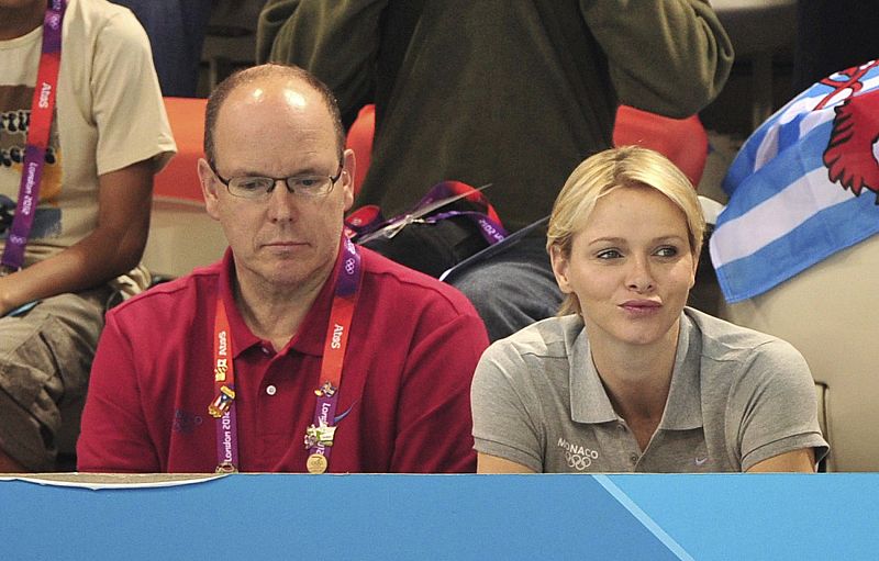 El príncipe Alberto de Mónaco y su esposa la princesa Charlene observan desde la grada las competiciones de natación de los Juegos Olímpicos de Londres 2012.