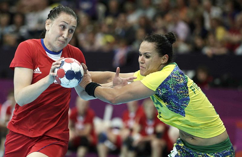 La jugadora de Brasil Daniela Piedade defiende la acción de la jugadora de Rusia Liudmila Postovna, durante el partido del torneo olímpico de balonmano.