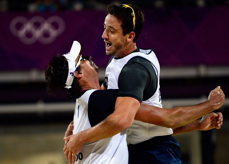 Los brasileños Ricardo Santos -la muralla- y Pedro Cunha celebran su victoria sobre la pareja española de vóley-playa formada por Pablo Herrera y Adrián Gavira, que se despiden de los Juegos Olímpicos de Londres tras perder en lo octavos de final de