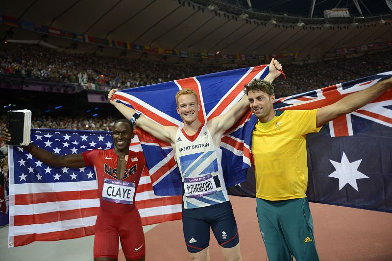 De izquierda a derecha, Will Claye, plata, Greg Rutherford, oro, y Mitchell Watt, bronce, celebran su triunfo de salto de longitud.