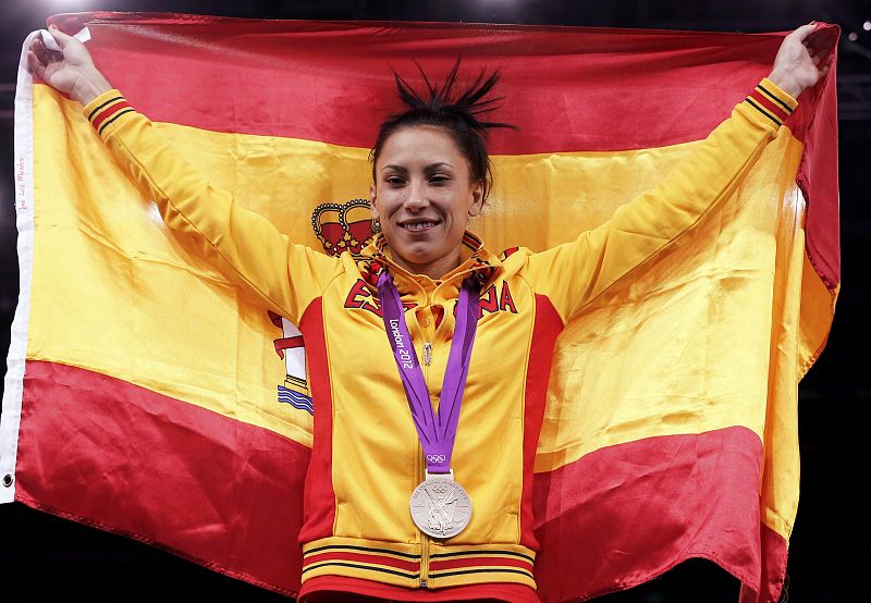 Silver medallist Spain's Brigitte Yague Enrique holds up a national flag at the women's -49kg taekwondo victory ceremony during the London 2012 Olympic Games at the ExCeL arena