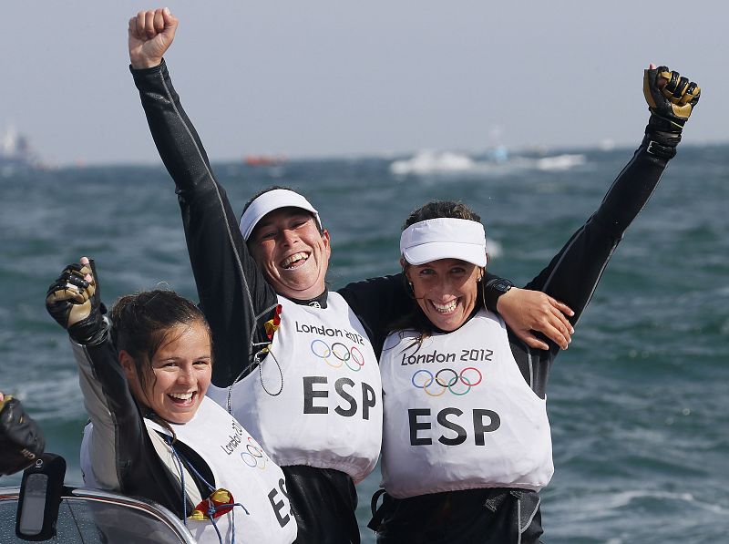 Tamara Echegoyen, Sofia Toro y Angela Pumariega celebran su victoria y el oro olímpico en la categoría Elliot 6m, la tercera medalla de oro para la delegación española.