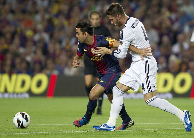 Xavi Hernández es presionado por el defensa del Real Madrid Sergio Ramos durante el partido.