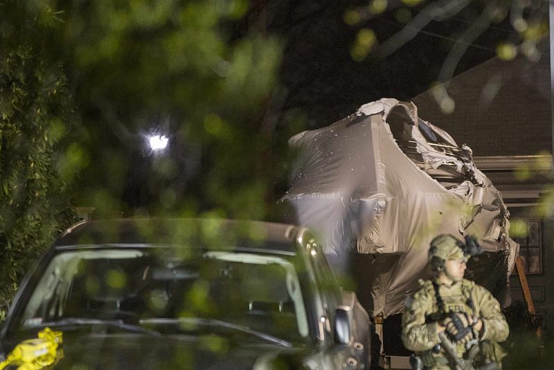 An FBI officer stands in front of the boat at 67 Franklin St. where Dzhokhar Tsarnaev, suspect in Boston Marathon bombings, was hiding inside in Watertown