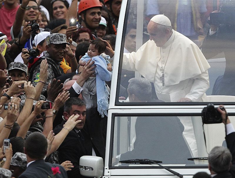 El papa Francisco impone su mano sobre la cabeza de un bebé durante su recorrido por las calles de Río de Janeiro, durante la Jornada Mundial de la Juventud