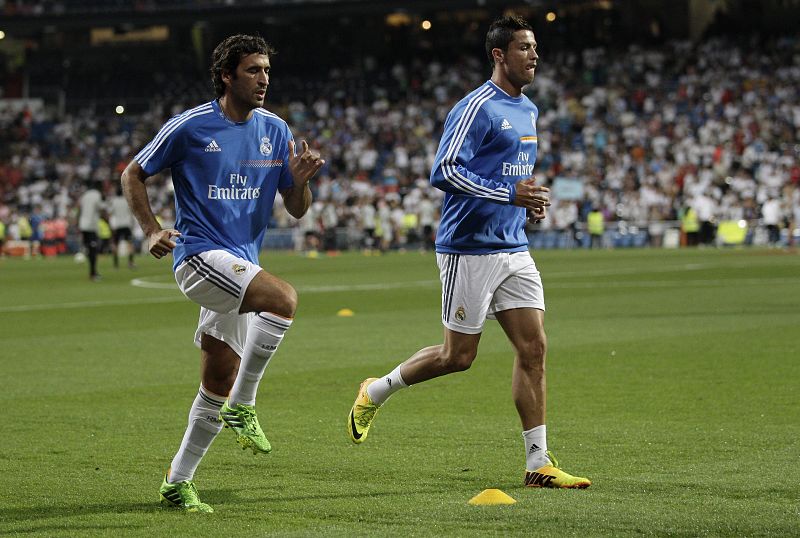 Raúl Gonzalez (i), con la indumentaria del Real Madrid, y el delantero del conjunto blanco Cristiano Ronaldo (d), calientan momentos antes del partido