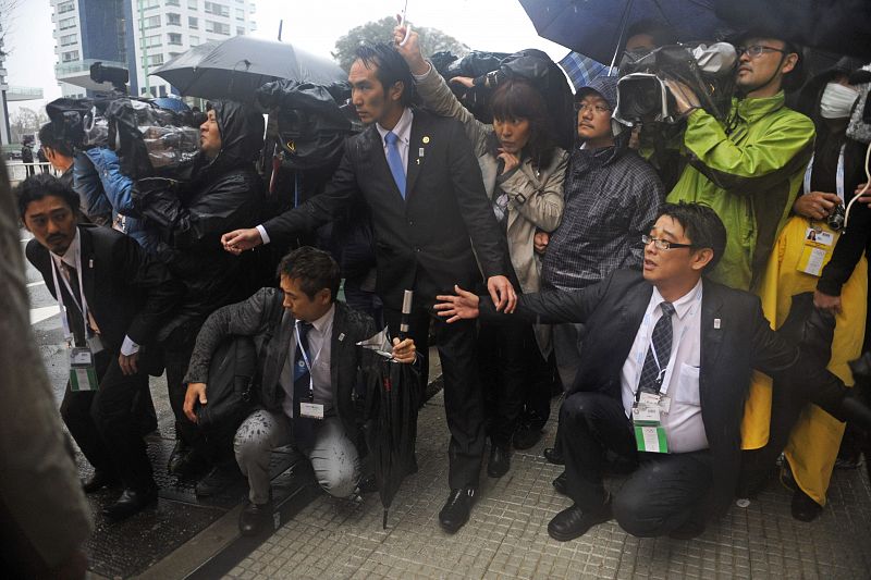 Periodistas japoneses bajo la fuerte tormenta que aguó la jornada en Buenos Aires.