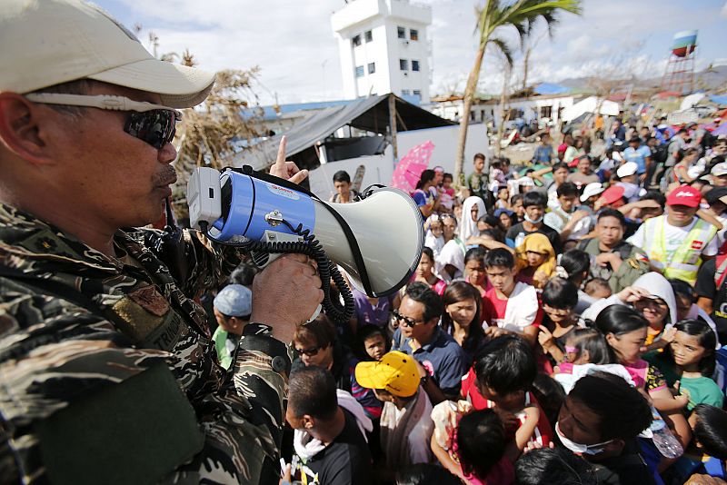 Un soldado filipino intenta calmar a la multitud que espera embarcar en un avión con destino a Manila en el aeropuerto de Tacloban