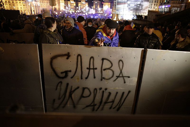 Protester gestures as he stands behind security fences used by police during a demonstration at Independance Square in Kiev