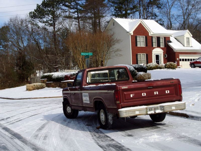 Una pick-up transporta arena para extenderla sobre la carretera helada.