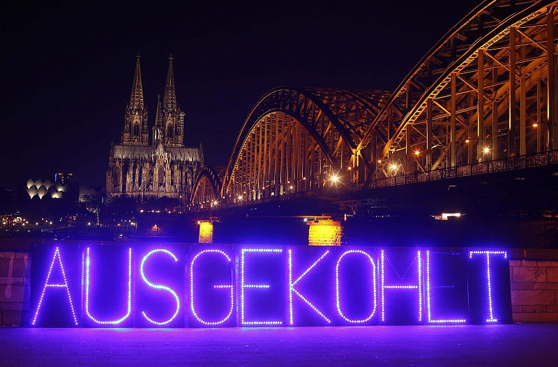 Lighted panel is seen in front of the UNESCO World Heritage Cologne Cathedral and the Hohenzollern railway bridge along the river Rhine before Earth Hour