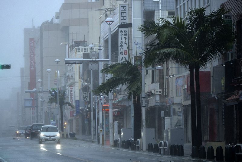 El viento sacude los árboles en una calle casi desierta en Naha, Okinawa.