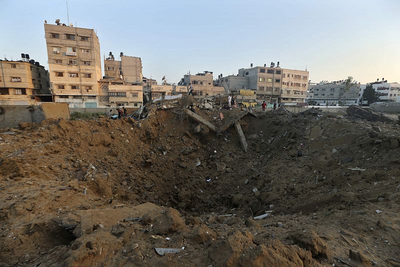 Un grupo de palestinos frente a los escombros de una casa destruida durante la ofensiva israelí en la ciudad de Gaza.
