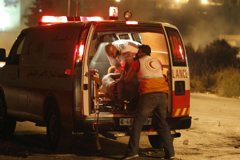 Un palestino es trasladado a una ambulancia tras los enfrentamientos entre palestinos y soldados israelíes en Cisjordania.
