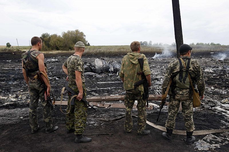 Armed pro-Russian separatists stand at the site of a Malaysia Airlines Boeing 777 plane crash near the settlement of Grabovo in the Donetsk region