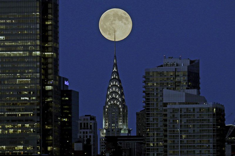 La luna llena vista detras del edificio Chrysler en Nueva York.