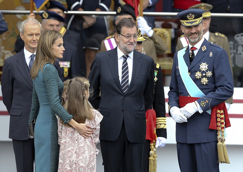 El rey Felipe , la reina Letizia , la princesa Leonor, la infanta Sofía, el ministro de Defensa; Pedro Morenés,iz., y el presidente del Gobierno, Mariano Rajoy,c, tras el desfile militar.