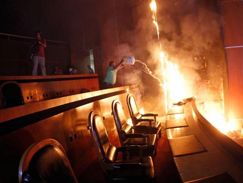 Un hombre intenta extinguir las llamas en el Congreso de Guerrero. Foto: REUTERS/Jorge Dan Lopez