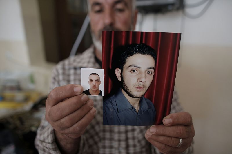 Un familiar de Uday (izquierda) y Ghasan Abu Yamal (derecha) muestra sus fotografías
