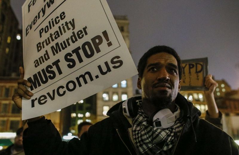 Un hombre muestra un panfleto en contra de la violencia policial durante la protesta celebrada en Union Square tras la decisión del gran jurado de no inculpar a un policía en la muerte de Eric Garner.