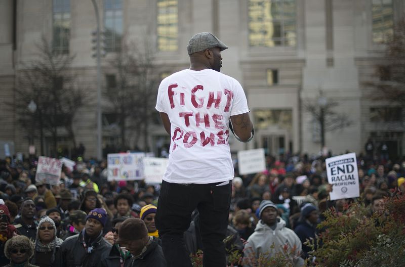 En la manifestación, bajo el lema "Justicia para todos", un manifestante expone una camiseta con el lema "Lucha contra el poder"