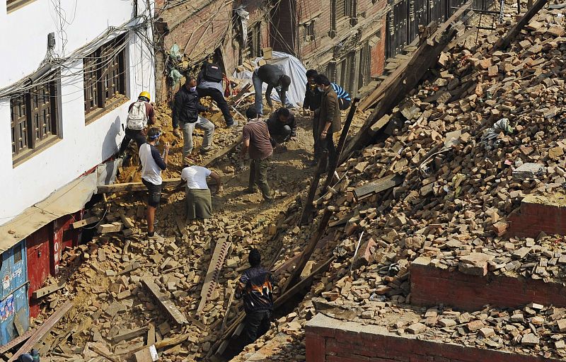 Vecinos buscan entre los cascotes a posibles supervivientes en la plaza de Durbar, en Katmandú