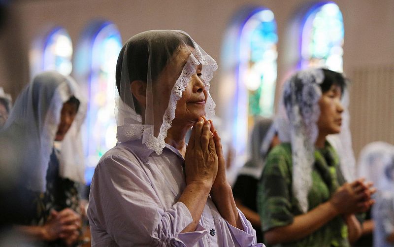 Unas mujeres rezan por las víctimas