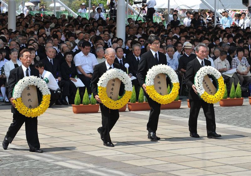 El alcalde de Nagasaki, Tomihisa Taue, y otros representantes, ofrecen plegarias y flores durante la ceremonia