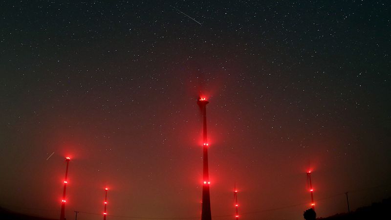 Fotografía con larga exposición que muestra un meteoro cruzando el cielo y en primer plano generadores de viento, hoy miércoles 13 de agosto de 2015, cerca a Gemuend (Alemania)